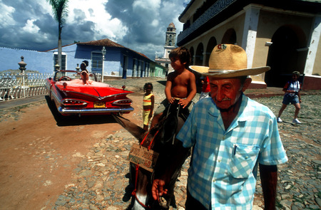 Donkey trip in Trinidad for children. Classic red 1959 beautiful Chevy convertible on cobblestone street of Trinidad Cuba an old colonial villageのeditorial素材