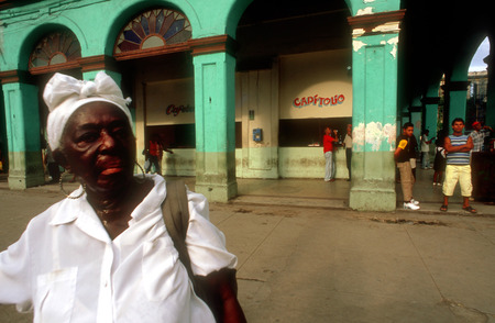 Woman santera passing the Capitolio Nacional, Havana, Cuba. SanterÃ­a, also known as Regla de OchÃ¡ or La Regla de LucumÃ­ is a syncretic religion of Caribbean origin which developed in the Spanish Empire among West African slaves. SanterÃ­a is influencedのeditorial素材