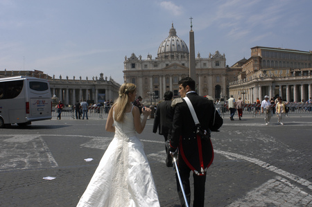 A bride and groom walk through St Peters Square in Vatican City, Italy.のeditorial素材