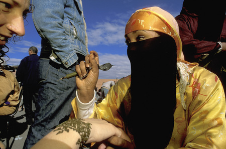 Woman applying a henna tattoo on a tourists hand in the Djemaa el-Fna market in Marrakech Moroccoのeditorial素材