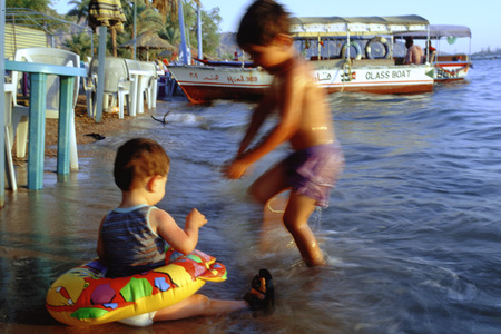 Children playing in the beach and Glass boats in the Acaba beach, Jordanの写真素材