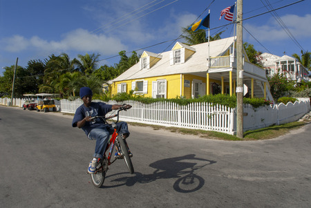 Child in a bicycle and loyalist home. Bay Street. Dunmore Town, Harbour Island, Eleuthera. Bahamasのeditorial素材