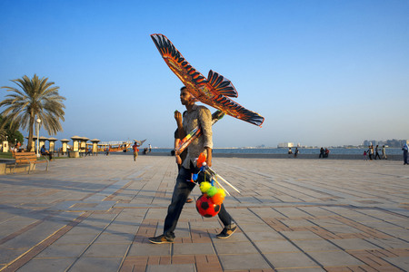 Kite seller. Modern skyline of the West Bay central financial district, Corniche promenade at Sheraton park Doha, Qatar, Middle Eastのeditorial素材