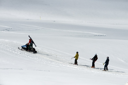 Baqueira Beret, Ski resort, Pyrenees, Aran Valley, Lleida, Catalonia, Spain. Line of people skiing with snowmobile.のeditorial素材