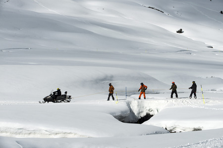 Baqueira Beret, Ski resort, Pyrenees, Aran Valley, Lleida, Catalonia, Spain. Line of people skiing with snowmobile.のeditorial素材