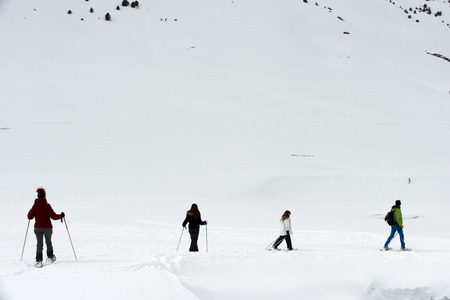 Baqueira Beret, Ski resort, Pyrenees, Aran Valley, Lleida, Catalonia, Spain. Line of people walking with snow rackets towards the summit of a snowy hill.のeditorial素材