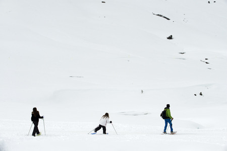 Baqueira Beret, Ski resort, Pyrenees, Aran Valley, Lleida, Catalonia, Spain. Line of people walking with snow rackets towards the summit of a snowy hill.のeditorial素材