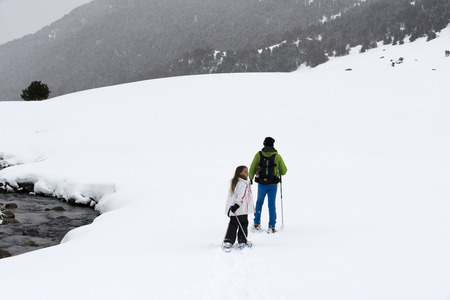 Baqueira Beret, Ski resort, Pyrenees, Aran Valley, Lleida, Catalonia, Spain. Line of people walking with snow rackets towards the summit of a snowy hill.のeditorial素材