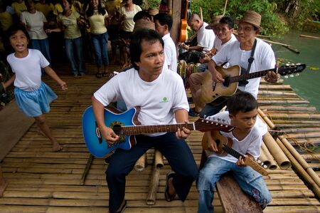 Some children sing and dance on the margins of the Loboc river when tourists arrive while they take...