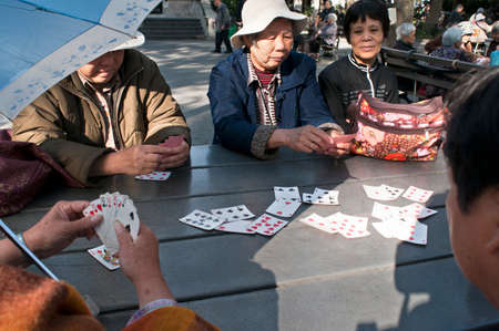 Chinese men playing cards in the Columbus Park Chinatown lower east side, Manhattan, New York, USA.のeditorial素材