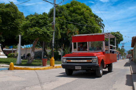 Red bus chevrolet in Choroni village in Falcon state in Venezuela - Henri Pittier National Park, in Venezuela.  It presents a big touristy interest, by being one of the starting points towards the islands of Morrocoy National Park, together with Tucacas.のeditorial素材