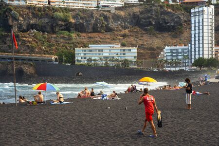 Tourists at los gigantes cliffs volcanic black sand beach in Puerto de la Cruz, Tenerife Island, Canary Islands, Spainの写真素材