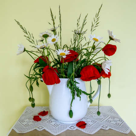 bouquet of daisies and poppies in a vaseの写真素材