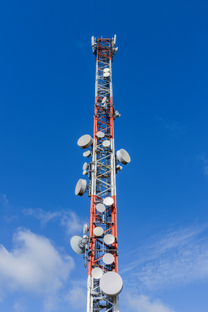 image of cellular antennas against a blue sky