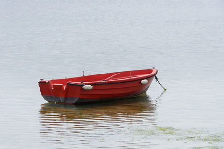image of red wooden fishing boat moored at the seaの写真素材