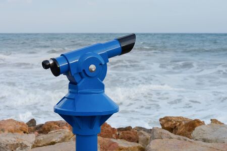 blue paid spyglass on the beach close-up on the background of the surf
