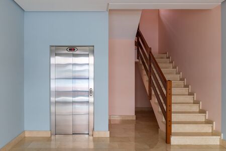 view of the elevator and stairwell in the entrance of a residential building