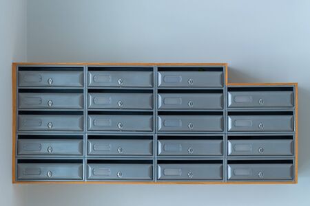 gray mailboxes on the blue wall of entrance of apartment houseの写真素材