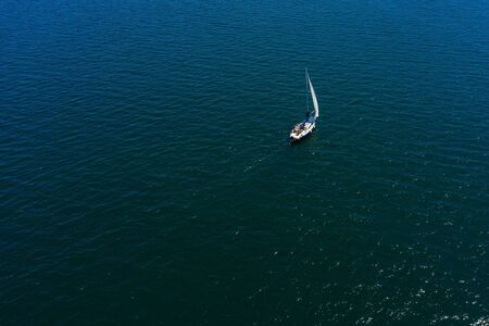 lonely white sailing yacht at sea, aerial view, drone shootingの写真素材
