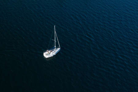 lonely white sailing yacht at sea, aerial view, drone shootingの写真素材