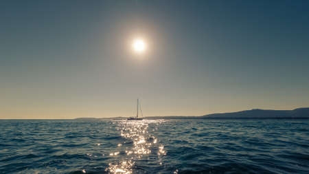 beautiful sailing yacht on the horizon at sunset, beautiful natural landscape, toning effectの写真素材