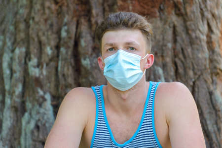 young man with medical mask on wood backgroundの写真素材