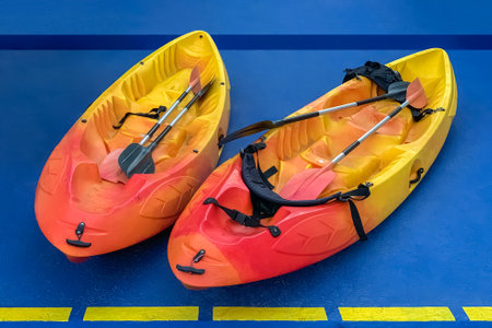 two colorful canoes with oars on a blue background