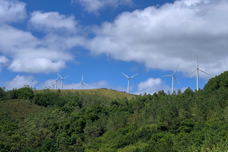 wind power plants against a blue sky with clouds on a bright sunny day