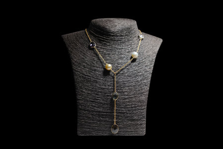 beautiful pearl necklace on a mannequin isolated on black backgroundの写真素材