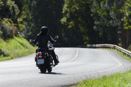 man on a custom classic motorcycle rides down the road, road trafficの写真素材