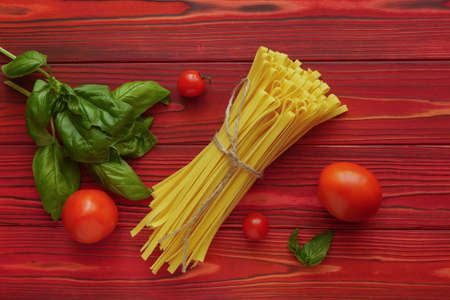 Bunch of tagliatelle on a red wooden backgroundの写真素材