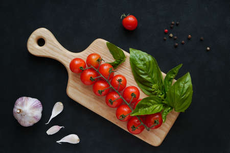 Basil with cherry tomatoes on a black backgroundの写真素材