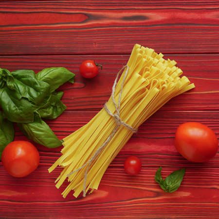 Bunch of tagliatelle on a red wooden backgroundの写真素材