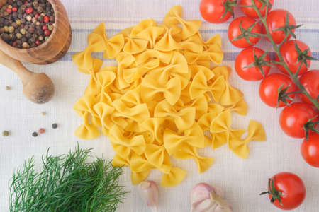 Farfalle pasta together with ingredients are ready for cookingの写真素材