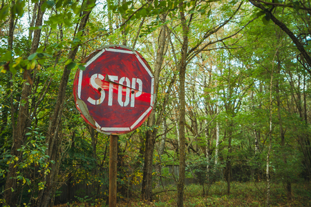 Stop sign - old rusty, frayed, scratched red road sign in radioactive zone in Pripyat city. Chornobyl exclusion zoneの写真素材