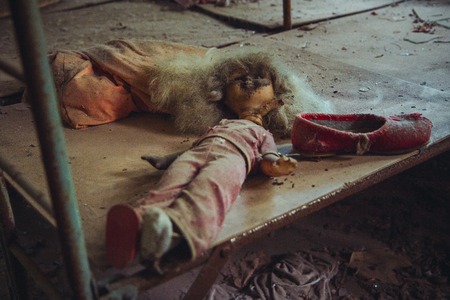 Old doll in Chornobyl exclusion zone. Radioactive zone in Pripyat city - abandoned ghost town. Chernobyl history of catastrophe. Lost place in Ukraineの写真素材