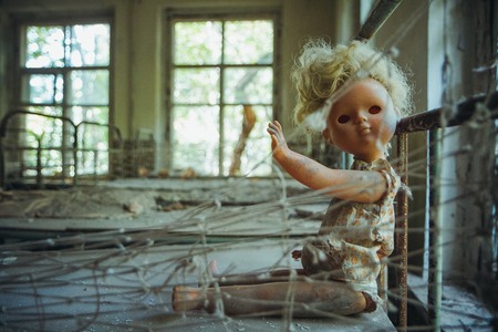 Old doll in Chornobyl exclusion zone. Radioactive zone in Pripyat city - abandoned ghost town. Chernobyl history of catastrophe. Lost place in Ukraineの写真素材