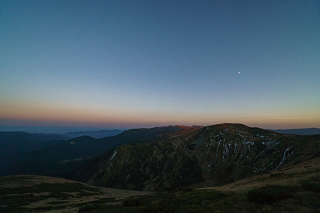 A little snow and moon above mountains sunset - landscape of the Ukrainian Carpathian Mountains, Chornohoraの写真素材