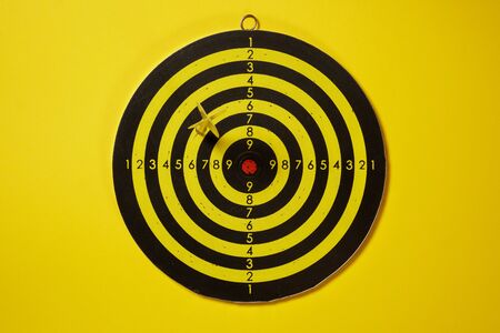Yellow arrow dart hitting the target dartboardの写真素材