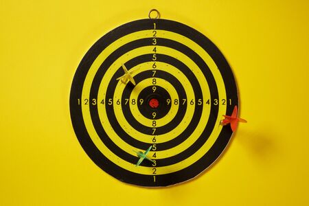 Yellow, red and green arrows darts hitting the target dartboardの写真素材