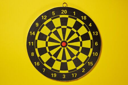 The empty target for a darts - dartboard isolated on yellow backgroundの写真素材