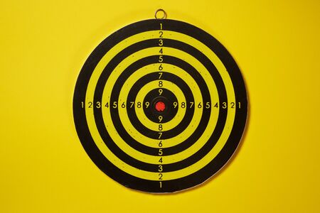The empty target for a darts - dartboard isolated on yellow backgroundの写真素材