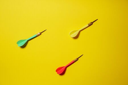 Single yellow, green and red arrows darts isolated on yellow backgroundの写真素材