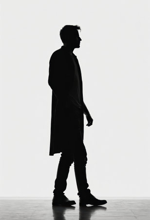 A solitary figure of a man in silhouette takes purposeful steps, showing a blend of elegance and thoughtfulness in a clean, monochromatic environment.の素材
