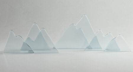 A serene and minimalist composition features a series of delicate, clear blue mountain silhouettes casting soft shadows on a clean gray surface, creating a peaceful scene.の素材
