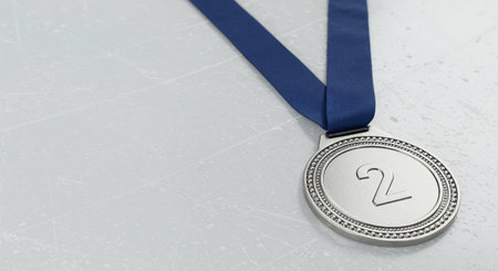 The gleaming second-place medal, featuring intricate beading around its edge and a bold number two, is displayed prominently with its blue ribbon on a subtly scratched, pale background.の素材