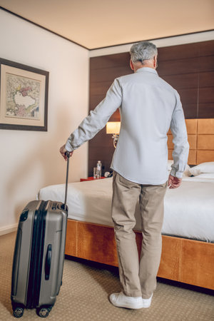Gray-haired good-looking man arrived to the hotelの写真素材