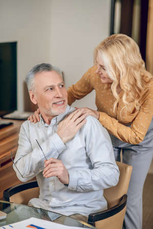 A man working from home, his wife standing next to himの写真素材