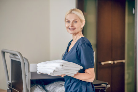 Service woman with towelsin hands smiling nicelyの写真素材