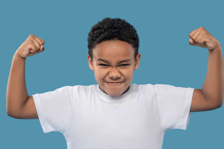 African American boy showing his strengthの写真素材